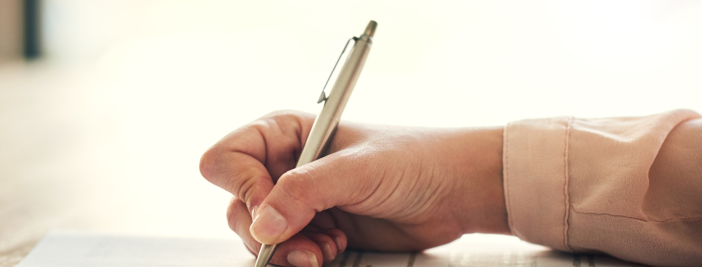 hand holding a pen to paper